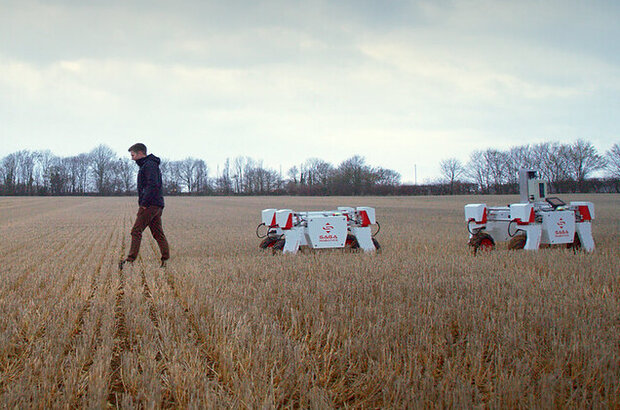 Engineer with sustainable agricultural robot in field