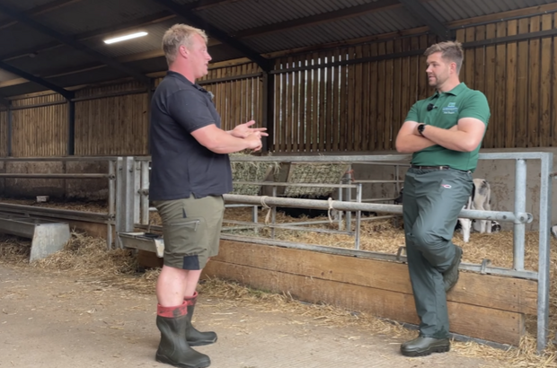 A farmer and vet in discussion in a barn during an annual health and welfare review