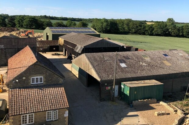 Aerial shot of a farm yard in the east of England, under sunny skies.