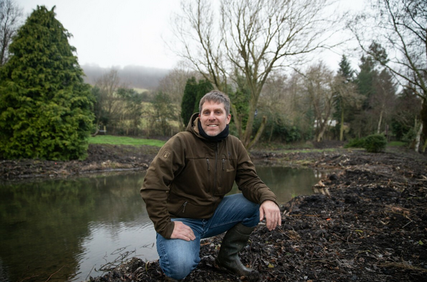 Michael Knight next to a restored pond on his farm 