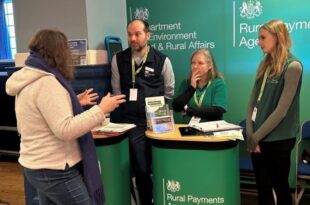 Defra ambassadors at an event, standing behind a desk