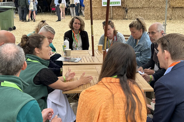 Alice Brown, pictured left, talking at an agricultural show in 2025. She is surrounded by a group of 10 people.